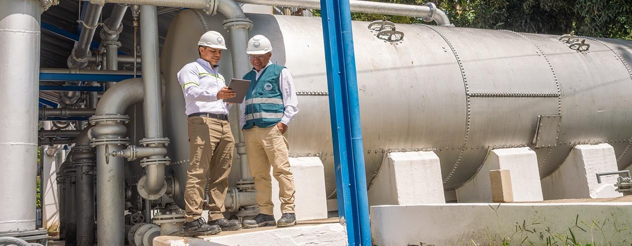 Dos integrantes del equipo de Mariscal junto a las instalaciones de tratamiento de agua